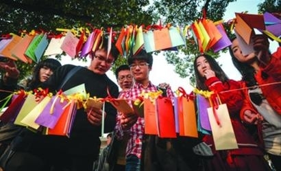 同济大学内一条道路边,男生们仔细阅读女生们的许愿卡。晨报记者 肖允 同济大学内一条道路边,男生们仔细阅读女生们的许愿卡。晨报记者 肖允